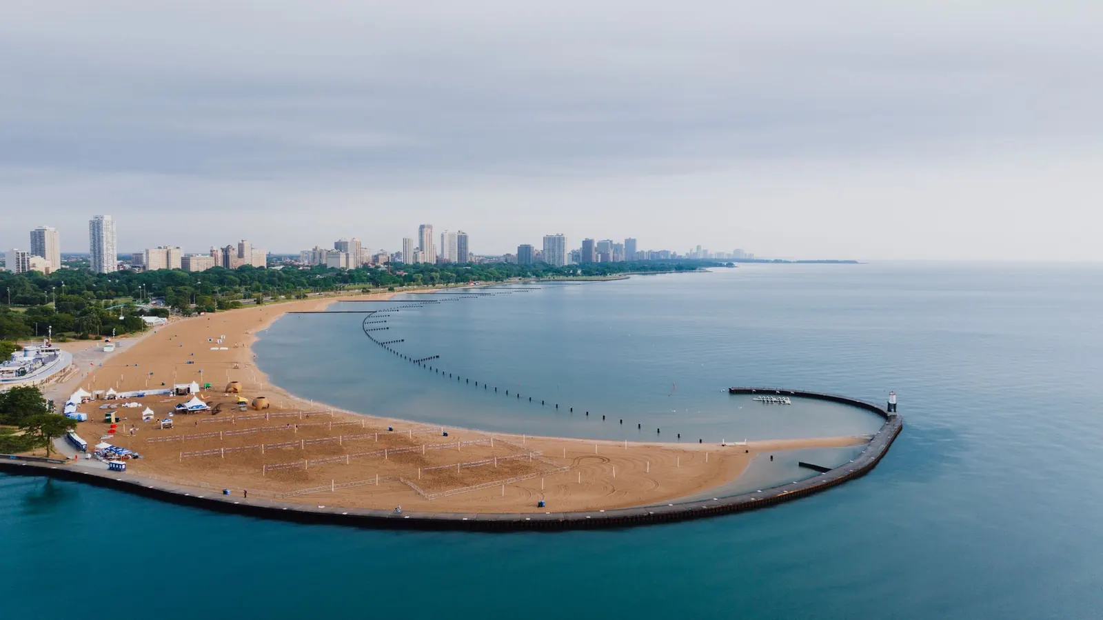 Curved sandy beach on Lake Michigan with the city behind it