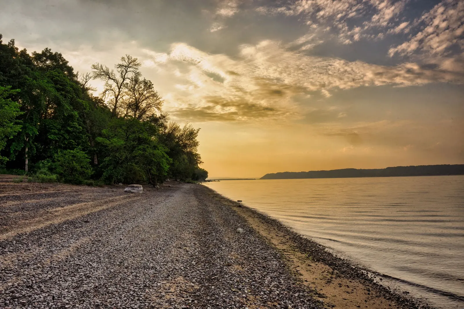 Shoreline path along a lake at sunset